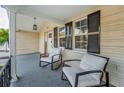 Relaxing front porch featuring two armchairs and a decorative 'welcome' sign at 7235 Astor Dr, New Port Richey, FL 34652