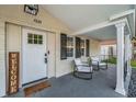 Inviting front porch with brick accents, seating area, and stylish decorative accents at 7235 Astor Dr, New Port Richey, FL 34652