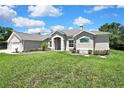 Charming single-story home boasts lush green lawn and inviting entrance with well-maintained landscaping at 7495 Birdland Cres, Spring Hill, FL 34607