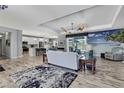 Open-concept living room with coastal decor, wood-look floors, and seamless flow to kitchen at 7495 Birdland Cres, Spring Hill, FL 34607
