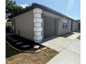 Angle of the home's exterior, displaying an attached garage, fresh landscaping, and a well-kept lawn at 8413 Monarch Dr, Port Richey, FL 34668