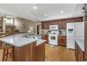 Well-lit kitchen featuring a breakfast bar, wood cabinets, and white appliances at 8514 Ashbury Dr, Hudson, FL 34667