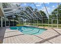 Enjoy this screened-in pool with brick pavers and outdoor seating, perfect for relaxing and entertaining at 888 Royal Birkdale Dr, Tarpon Springs, FL 34688