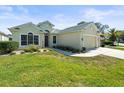 Inviting home featuring a manicured lawn, a two-car garage, mature trees, and beautiful landscaping at 9010 Penelope Dr, Weeki Wachee, FL 34613