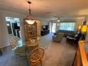Open-concept living room featuring carpet flooring, neutral walls and decorative lighting at 9186 Patio Ct, Spring Hill, FL 34608