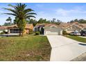 Charming single-story home with a well-manicured lawn, mature palm tree, and a two-car garage at 9355 French Quarters Cir, Weeki Wachee, FL 34613