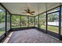 Relaxing screened lanai with ceiling fan and views of the landscaped backyard at 10106 Tolman Dr, Hudson, FL 34667
