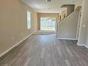 Bright and spacious living room featuring laminate flooring and sliding glass doors at 10238 Perthshire Cir, Land O Lakes, FL 34638