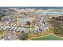 Aerial view of a neighborhood featuring a central lake with community amenities at 10823 Penny Gale Loop, San Antonio, FL 33576