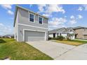 Side view of a two-story home with a large driveway and manicured lawn at 10823 Penny Gale Loop, San Antonio, FL 33576
