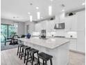 Spacious kitchen with white cabinetry, stainless steel appliances, and a granite island with seating at 11325 Juglans Dr, Odessa, FL 33556