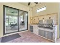 Covered outdoor kitchen with a built-in grill, sink, and counter space, perfect for entertaining at 11325 Juglans Dr, Odessa, FL 33556