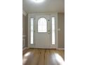 Elegant entryway with decorative glass front door, side windows, and beautiful wood-look flooring at 12210 Quail Run Row, Hudson, FL 34667