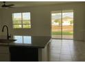 Open kitchen area with sliding glass doors leading to the backyard and natural light at 12630 Aston Dr, Hudson, FL 34669
