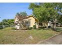 Quaint home featuring a lush lawn, mature trees, and an attached garage at 12906 Sandburst Ln, Hudson, FL 34667