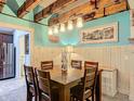 Charming dining room features light-blue walls, wood-paneled walls, exposed beam ceilings, and decorative lighting at 13111 Precept Way, Hudson, FL 34669