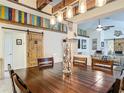 Open-concept dining room featuring barn doors, colorful accents, and a spacious wood table for entertaining at 13111 Precept Way, Hudson, FL 34669