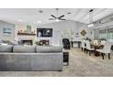 Open-concept living room with a fireplace, large TV, and dining area with stylish furnishings at 13373 Lawrence St, Spring Hill, FL 34609