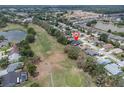 Aerial view of a neighborhood featuring a golf course and a lovely lake at 13524 Knotty Ln, Hudson, FL 34669