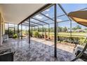 Screened-in patio featuring tile flooring, comfortable seating, and views of the backyard at 1420 Winding Willow Dr, Trinity, FL 34655