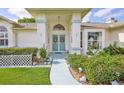 Inviting front entrance with decorative security door and lush garden area at 1496 Overland Dr, Spring Hill, FL 34608