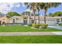 Beautiful single-story home with palm trees, green lawn, and lovely curb appeal at 1496 Overland Dr, Spring Hill, FL 34608