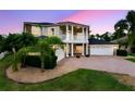 Beautiful two-story home with mature landscaping, a brick driveway, and a three-car garage at 15906 Prince William Pl, Odessa, FL 33556