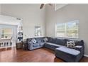 Comfortable living room featuring hardwood floors, a plush sofa, and large windows at 18061 Glastonbury Ln, Land O Lakes, FL 34638