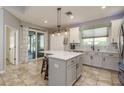 Bright kitchen with a center island, pendant lighting, modern appliances, and a tile backsplash at 1810 Winsloe Dr, Trinity, FL 34655