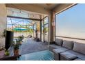 Comfortable covered patio with cozy seating, string lights, and a view of the sparkling pool area at 1810 Winsloe Dr, Trinity, FL 34655