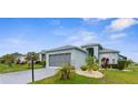 Charming single-story home with a gray roof, two-car garage, well-maintained landscaping, and covered entry at 18209 Breland Dr, Hudson, FL 34667