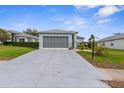 A light blue single-story home features a large driveway, gray roof, gray garage door, and manicured landscaping at 18209 Breland Dr, Hudson, FL 34667