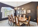 Close-up view of dining room table with seating for six, illuminated by a decorative chandelier at 18532 Myrtlewood Dr, Hudson, FL 34667