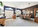 Formal dining room with dark accent wall and elegant chandelier above a wooden dining table at 18532 Myrtlewood Dr, Hudson, FL 34667