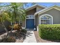 Inviting front entrance features a blue double door, decorative plants and well-manicured hedges at 18532 Myrtlewood Dr, Hudson, FL 34667