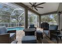 Inviting covered patio area with comfortable seating, a fire pit, and a view of the sparkling pool at 18620 Gracie Lee St, Spring Hill, FL 34610
