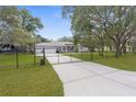 Charming single-story home with a gated entrance and lush green lawn, providing privacy and curb appeal at 18620 Gracie Lee St, Spring Hill, FL 34610