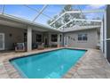 Refreshing screened-in pool with brick pavers and plenty of space for lounging, ideal for outdoor enjoyment at 18620 Gracie Lee St, Spring Hill, FL 34610