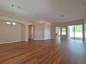 Open-concept space with hardwood floors, arched doorway, and chandelier lighting at 19855 Ellendale Dr, Land O Lakes, FL 34638