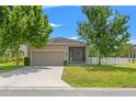 Well-maintained home featuring an attached two-car garage, screened lanai, and a white picket fence at 21167 Pleasant Plains Pkwy, Land O Lakes, FL 34637