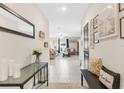 Inviting home entryway featuring modern decor, neutral color palette, tile flooring, and an open view to the living area at 2132 Shining Azul Way, Lutz, FL 33558