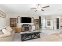 Spacious living room with ceiling fan, neutral tones, comfortable seating, tile floor, and a modern decor at 2132 Shining Azul Way, Lutz, FL 33558