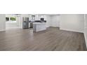 Open concept kitchen featuring hardwood floors, white cabinetry, a marble island, and stainless steel appliances at 2175 Edythe Dr, Dunedin, FL 34698