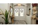 Bright foyer featuring double doors with stained glass, neutral colors, and tasteful decor at 3102 Lema Dr, Spring Hill, FL 34609