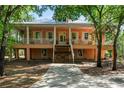 Two-story home with a large, inviting wraparound porch and mature trees in a serene setting at 3431 Riderwood Dr, Dade City, FL 33523