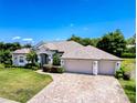 Aerial view of a single-story home with a brick driveway, well-maintained lawn, and mature trees at 3464 Misty View Dr, Spring Hill, FL 34609