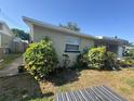 The side of the home featuring well-maintained landscaping with lush bushes and garden at 5316 Drift Tide Dr, New Port Richey, FL 34652