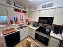 Functional kitchen with modern appliances, neutral cabinets, and an adjacent breakfast bar at 6410 Spring Flower Dr # 26, New Port Richey, FL 34653