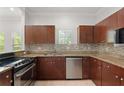 Kitchen with granite countertops, stainless appliances, and dark wood cabinets at 658 Siren Wind Ln, Clearwater, FL 33756