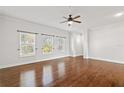 Bedroom with wood floors, three windows, and a ceiling fan at 658 Siren Wind Ln, Clearwater, FL 33756